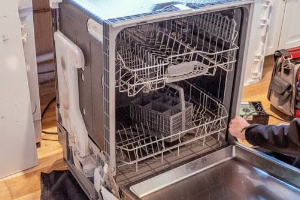 Technician repairing a dishwasher